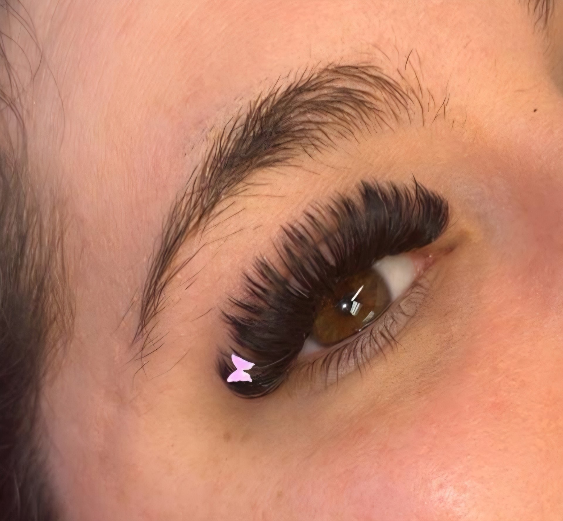 Close-up of mega volume lash extensions with butterfly charm accent at Ash's Lashes and Esthetics