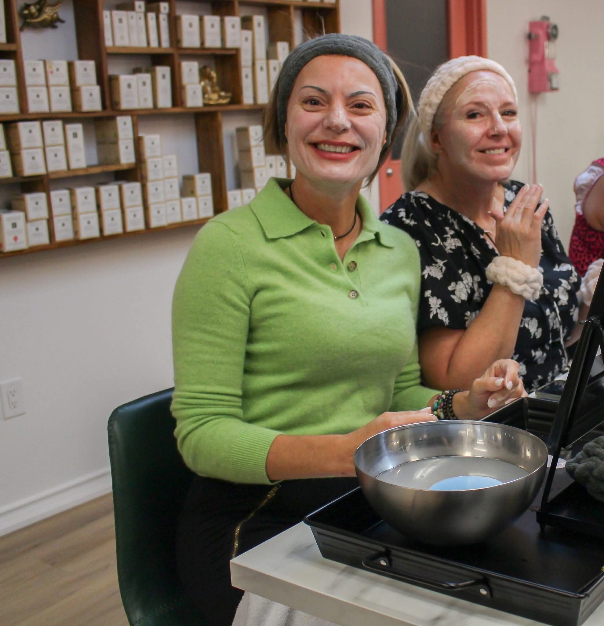 Two women smiling with face masks on during a You Dew You guided facial event at Ash's Lashes